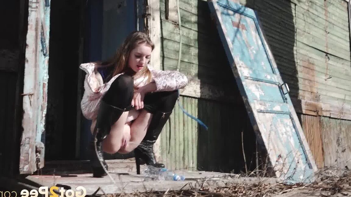 15P Solo girl Vika pulls down black leggings before squatting to pee by a building