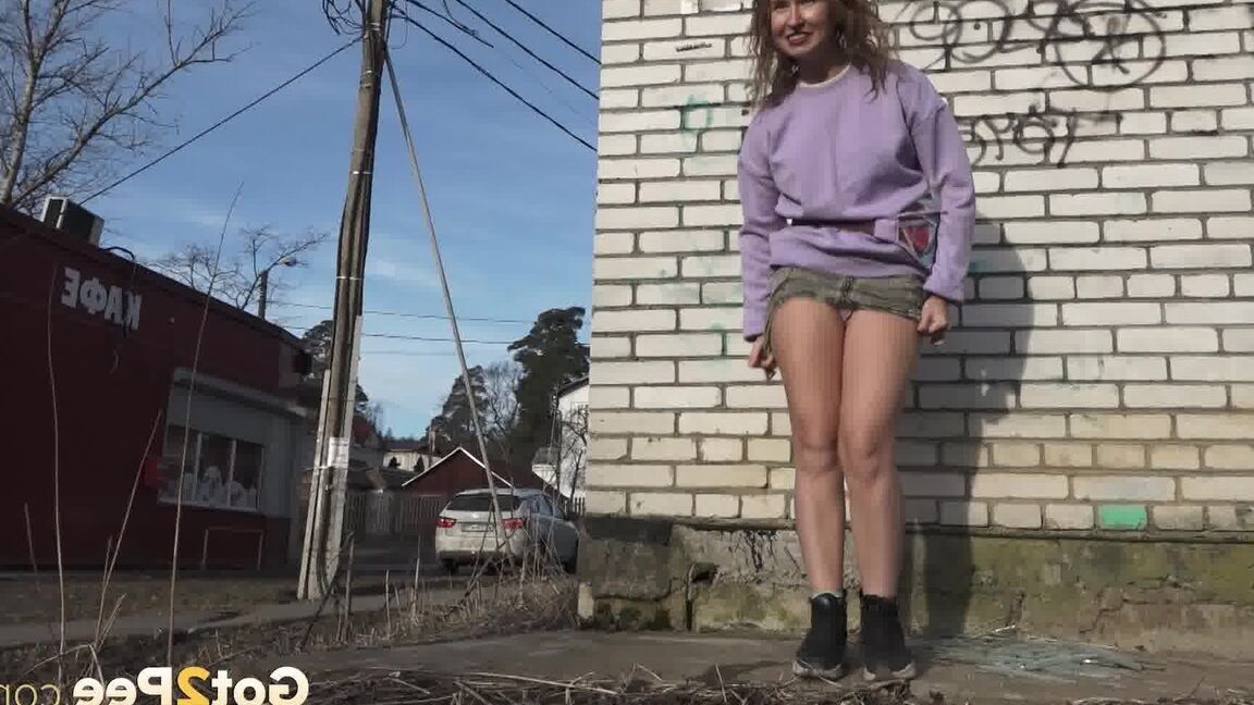 15P ショートショットの女の子リタが緊急の小便をするために建物の後ろに隠れる