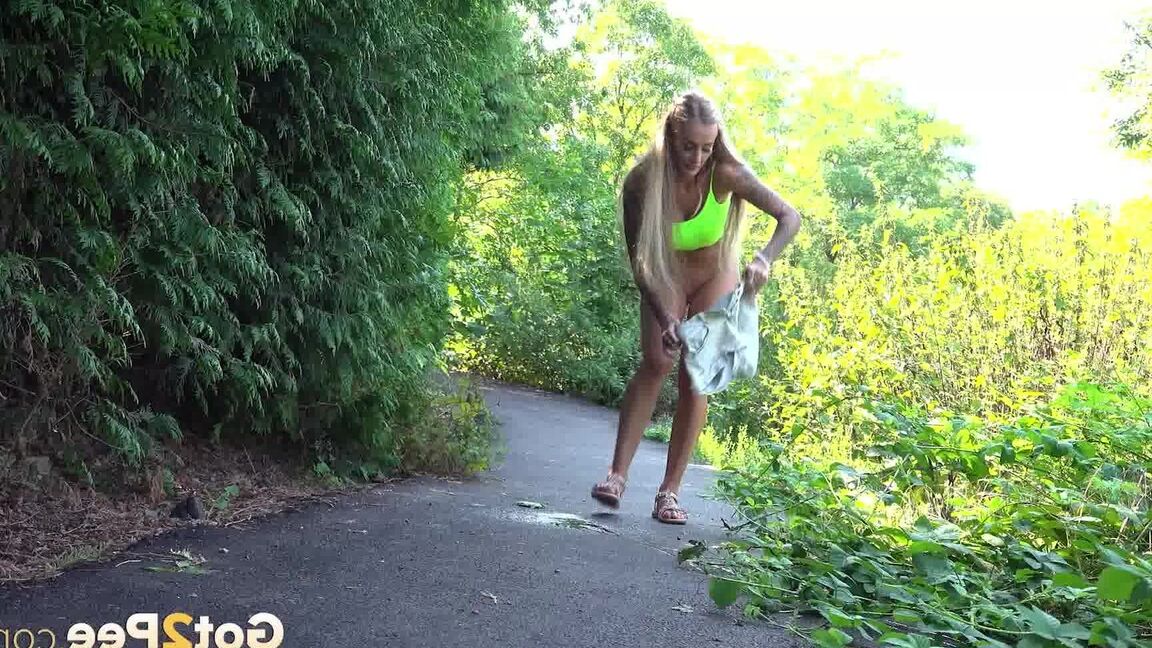 15P Blonde teen Daisy Lee takes a piss on a paved path through the woods
