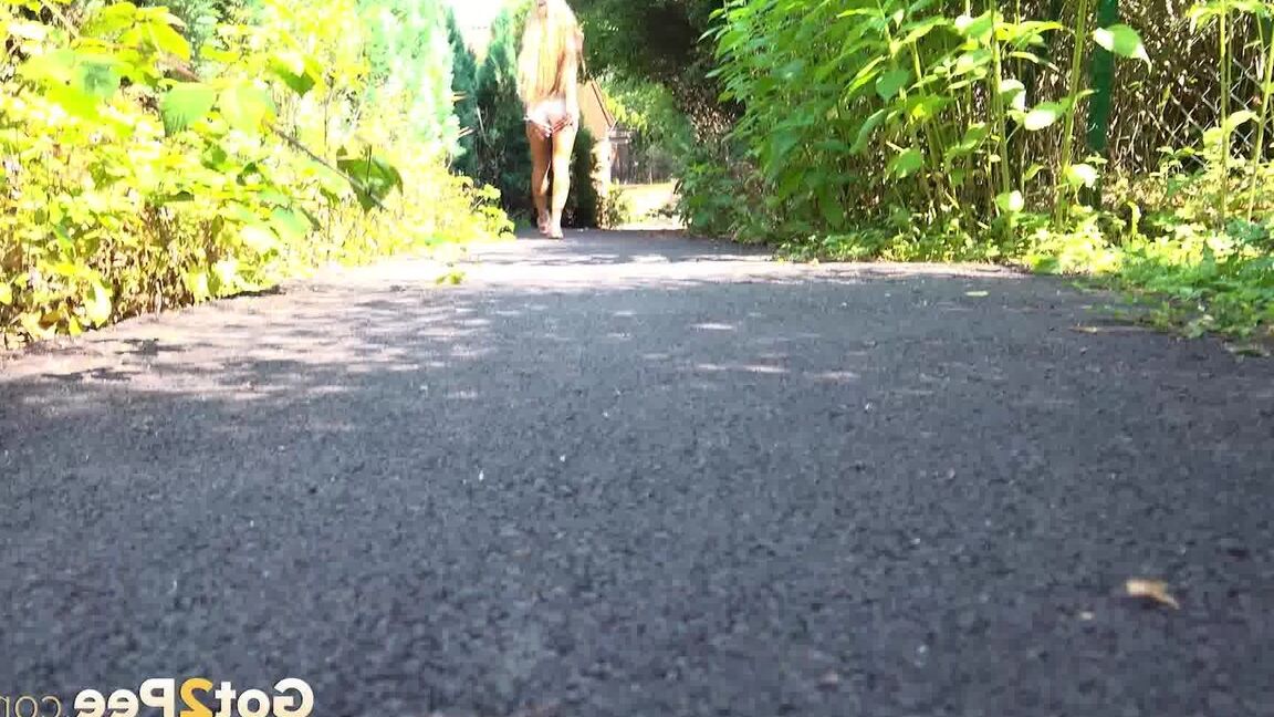 15P Blonde teen Daisy Lee takes a piss on a paved path through the woods