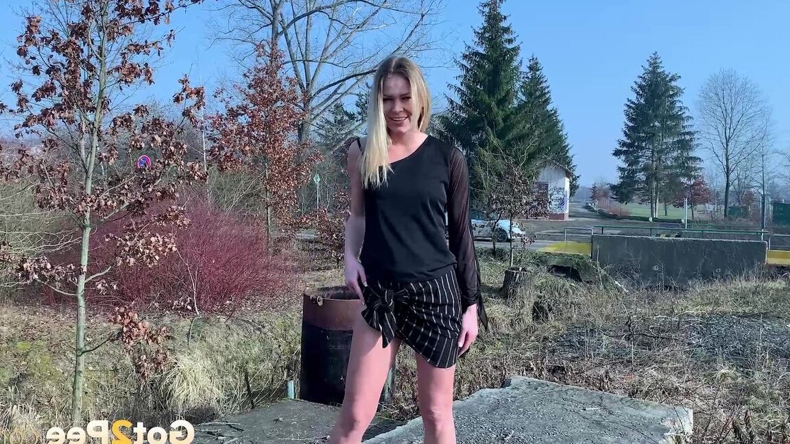 15P Blonde chick Claudia Macc squats for a piss on a concrete pad in black UGGs