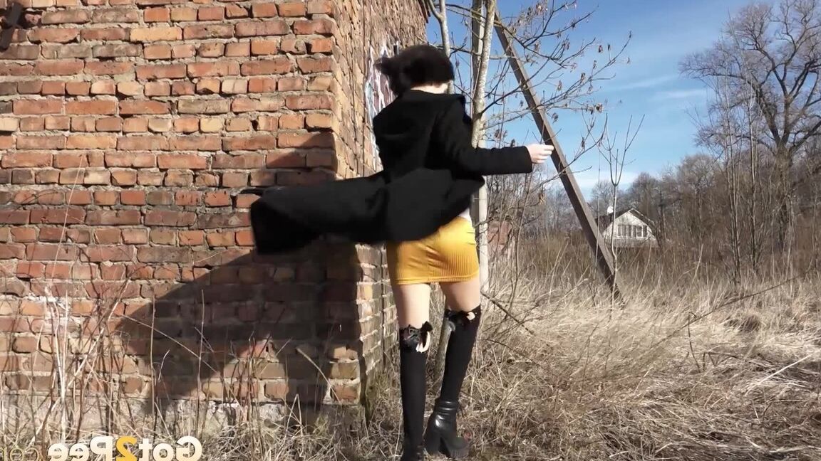 15P 黒髪のソロ少女がミニスカートを下ろしてレンガ造りの建物のそばでおしっこをする