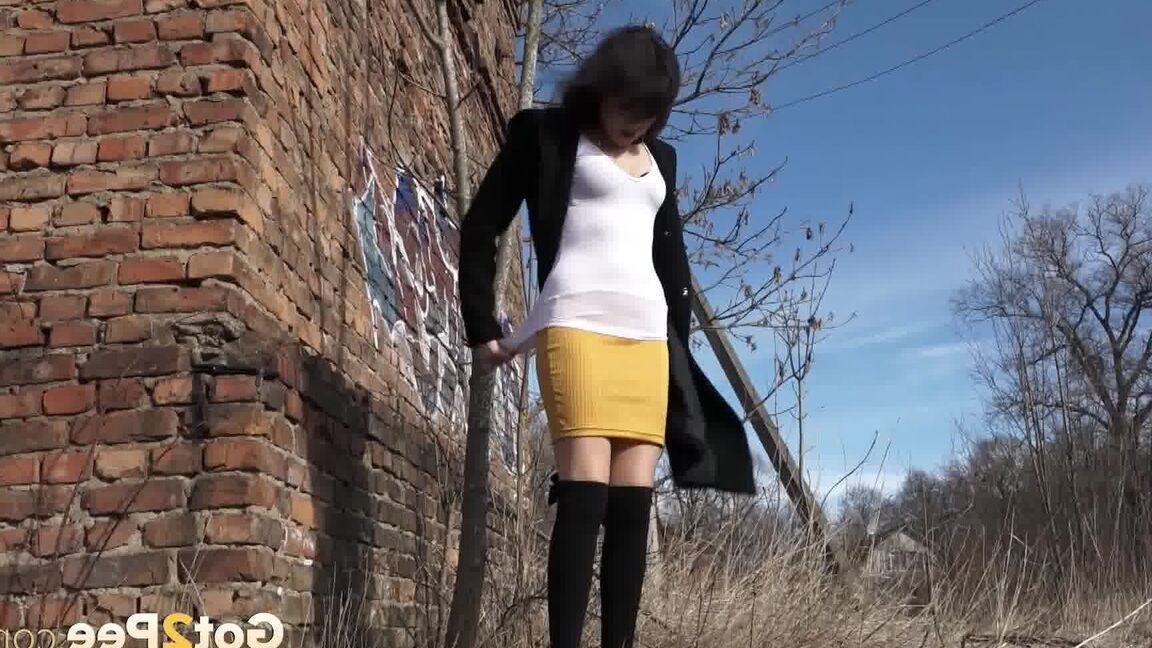 15P 黒髪のソロ少女がミニスカートを下ろしてレンガ造りの建物のそばでおしっこをする