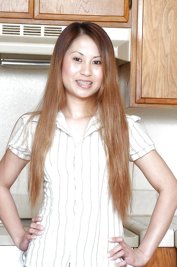 Cristina, amateur asiatique 16P, lâche ses petits seins de sa chemise dans la cuisine