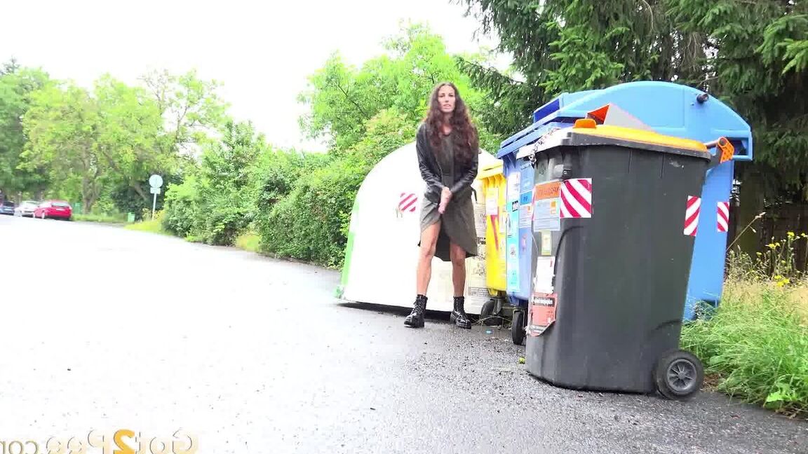 15P Short taken girl Ali Bordeaux squats for a piss on a road by refuse containers