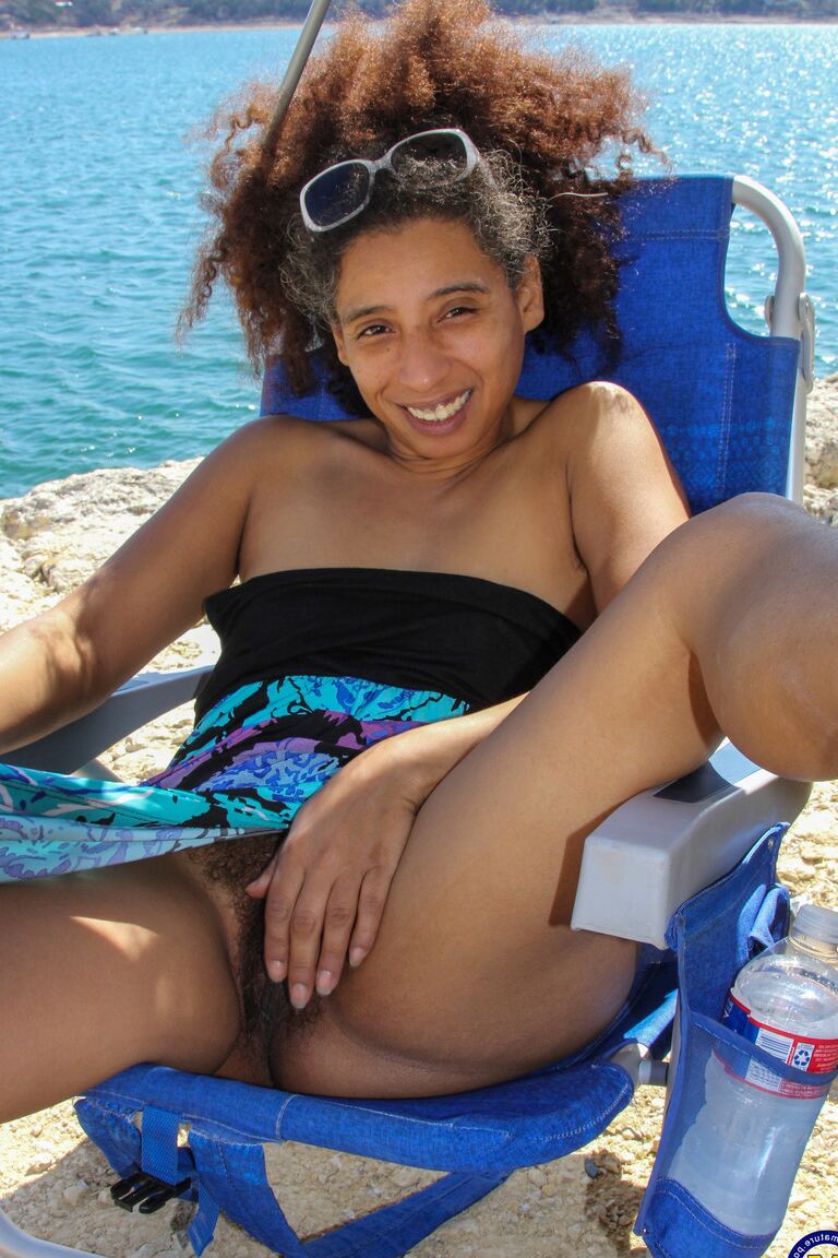 21P Mature ebony with hairy armpits Divine reveals her bushy cunt on the beach