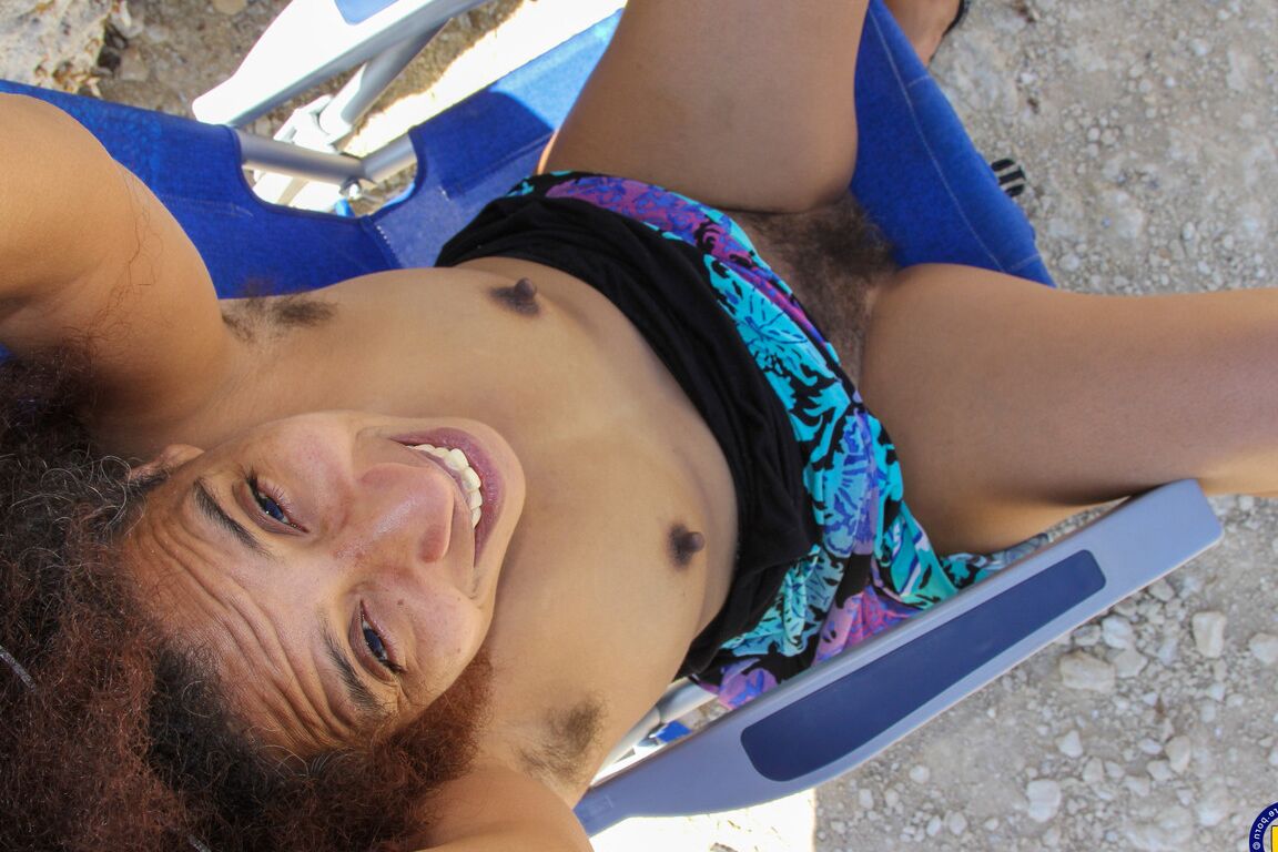21P Mature ebony with hairy armpits Divine reveals her bushy cunt on the beach