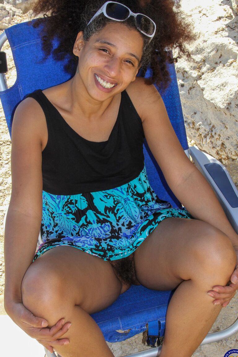 21P Mature ebony with hairy armpits Divine reveals her bushy cunt on the beach
