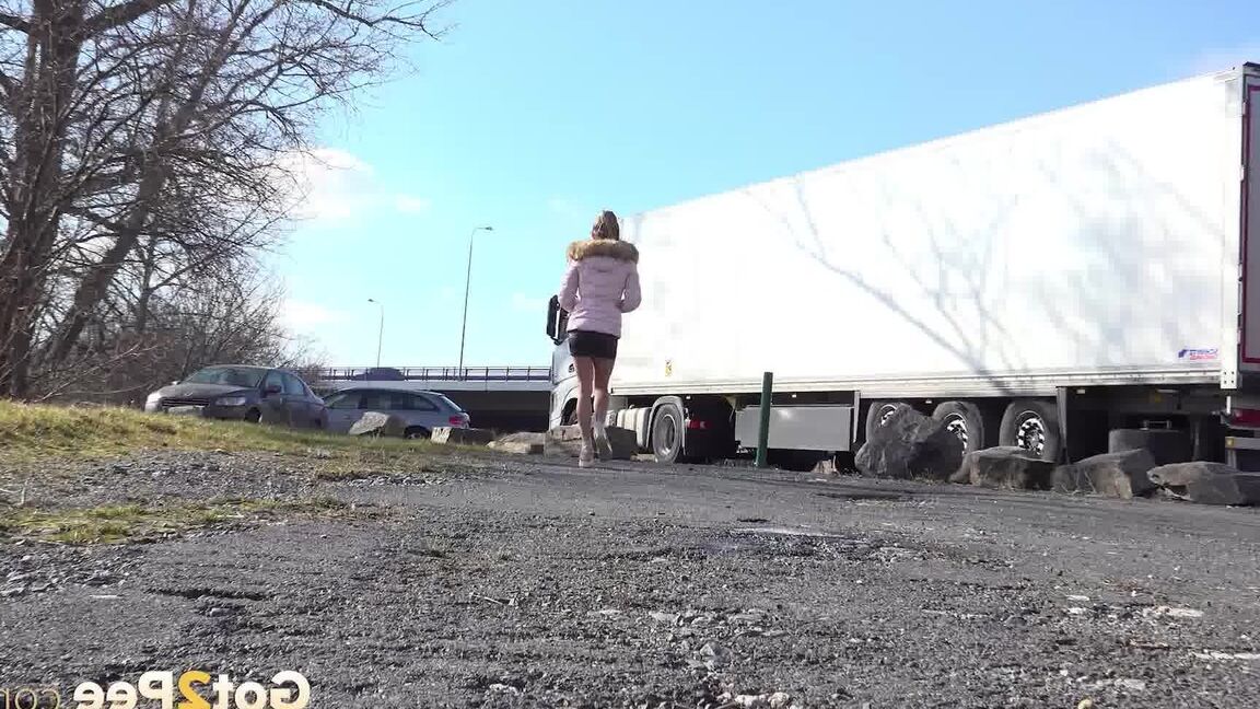 Das 15-jährige weiße Mädchen Isabel Dark pisst auf einem Kiesplatz und trägt große Rigs im Park