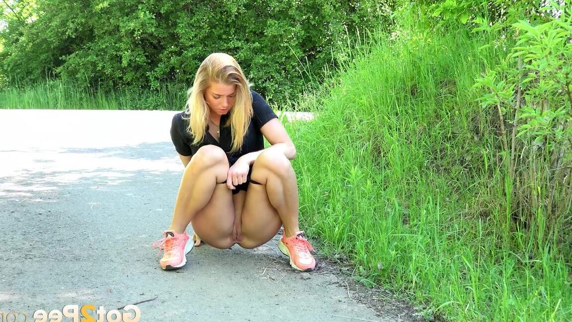 15P Blonde Chrissy squats to take a pee in the middle of the walking path
