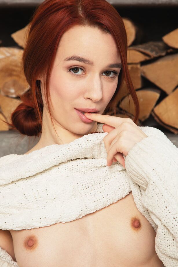 18P La joven pelirroja Sherice muestra su cuerpo flaco frente a la leña