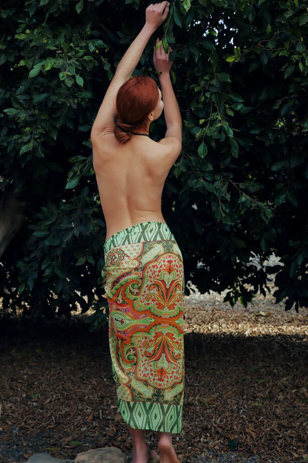 18P Young redhead Valery Leche removes a sari to pose naked in a garden setting
