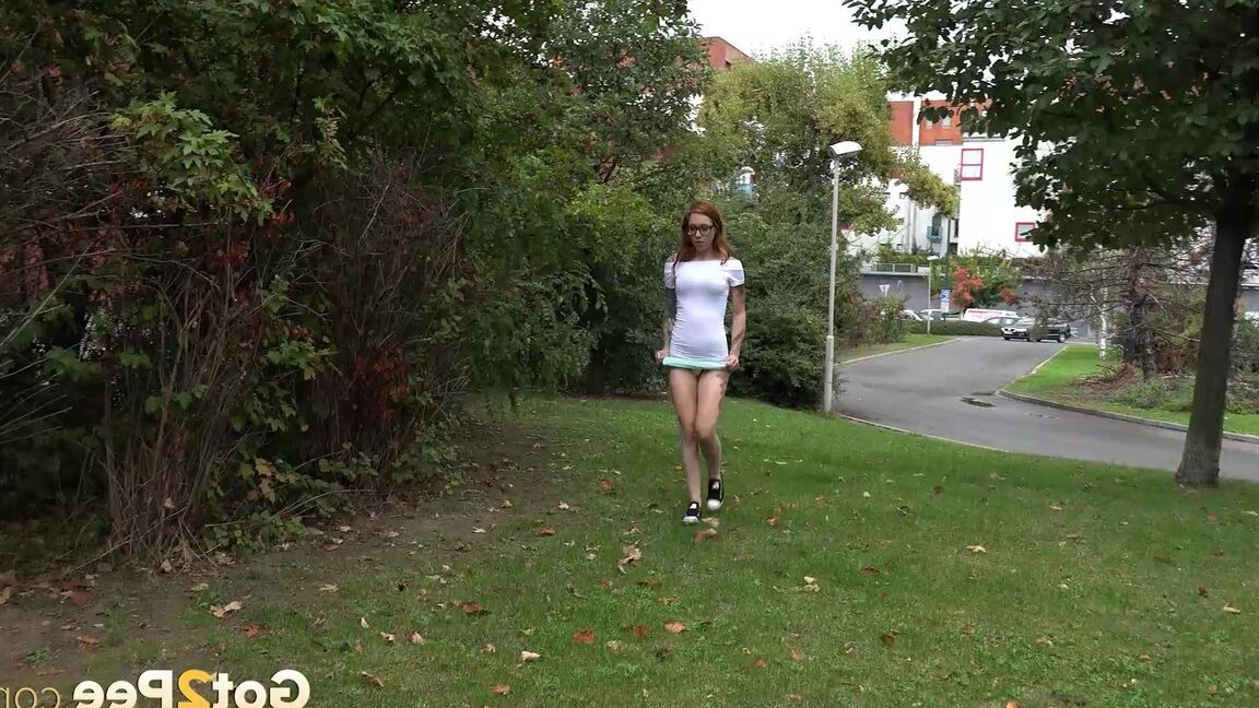 15P Une rousse à lunettes baisse sa culotte et fait pipi dans le parc