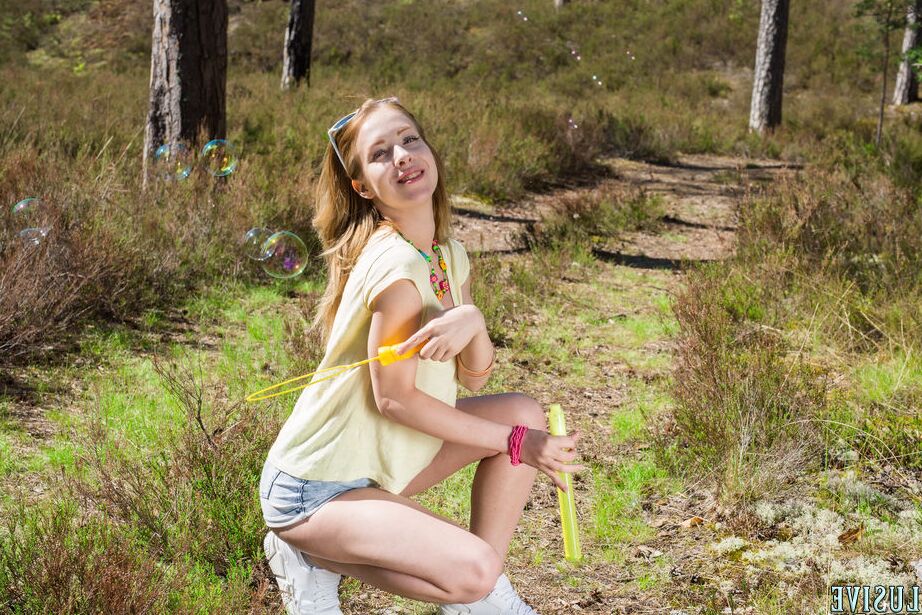 20P Young redhead Laska blows bubbles before posing naked in the woods