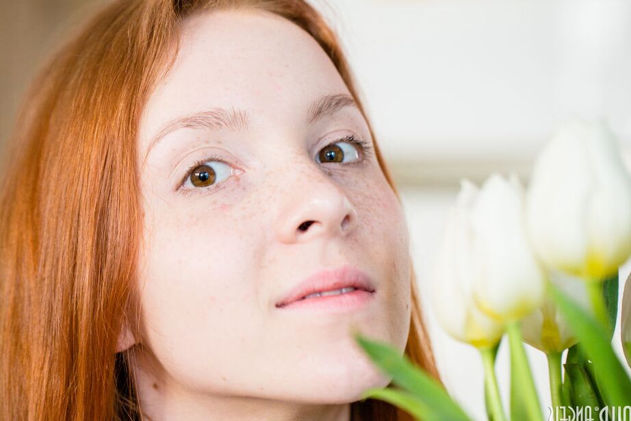 20P Une rousse pâle expose sa chatte rasée d'adolescente sur sa chaise préférée