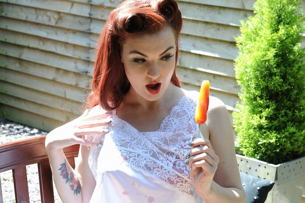 15P Redhead model Amber proudly shows her nice tits on a deck in retro pretties