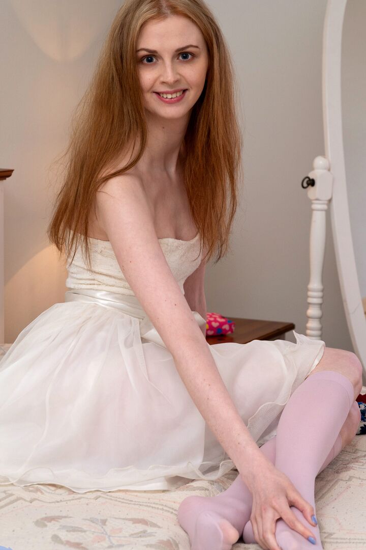 16P Pale redhead Linda Maers slips a finger in her pussy after disrobing on a bed