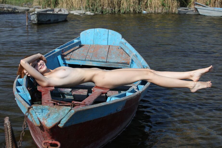 16P Natural redhead Viky C sets her teen body free of clothes on a dory