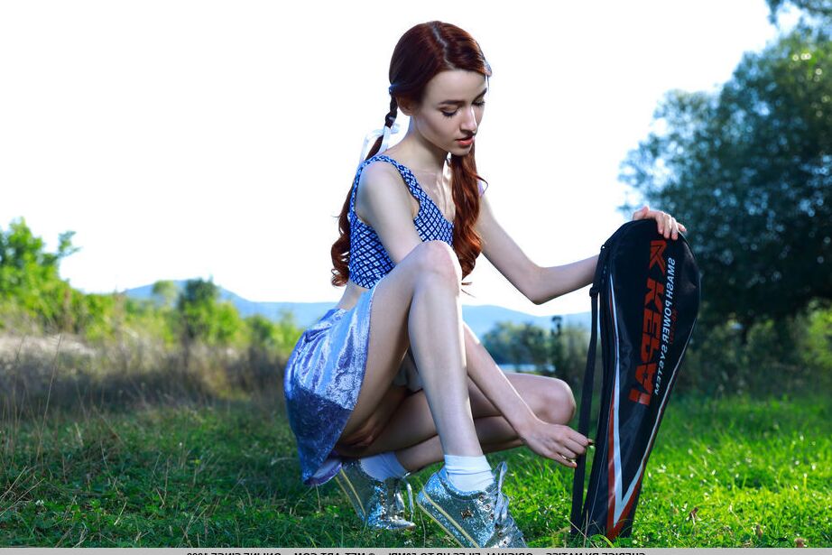 18P Young redhead Sherice pauses a badminton game to show her tight slit on grass