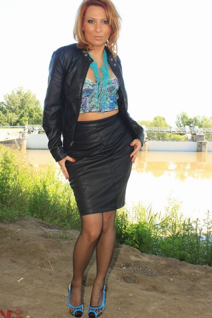 13P Clothed woman removes leather jacket and skirt by river in nylons and garters