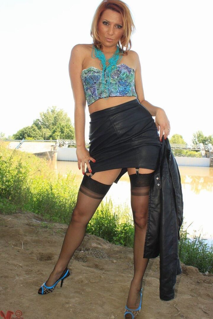 13P Clothed woman removes leather jacket and skirt by river in nylons and garters