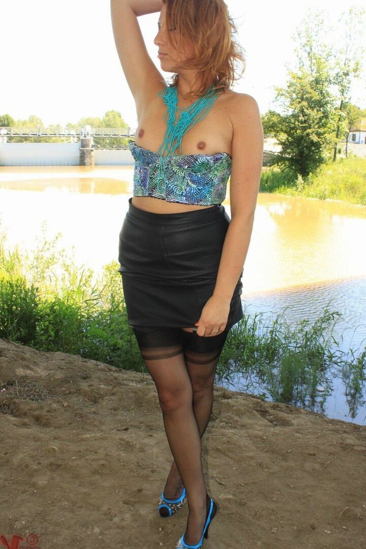 13P Clothed woman removes leather jacket and skirt by river in nylons and garters