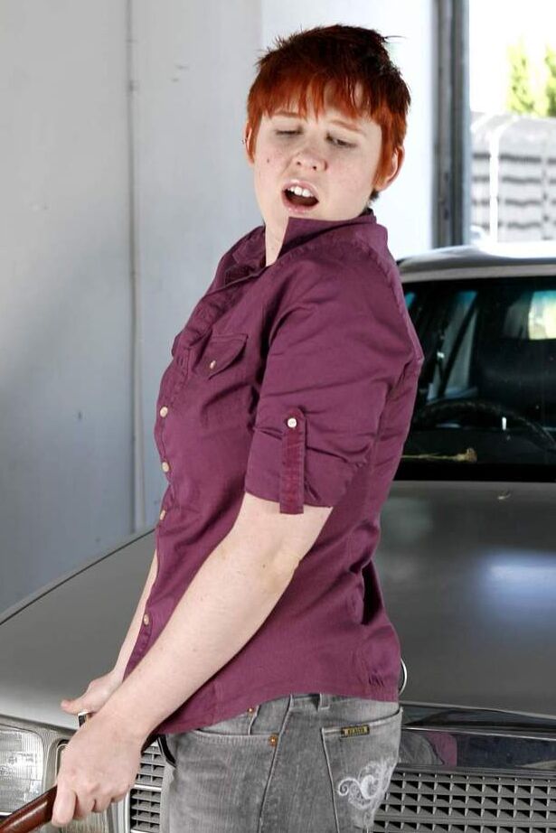 16P Short haired redhead Lily Cade strips naked atop a car in a garage