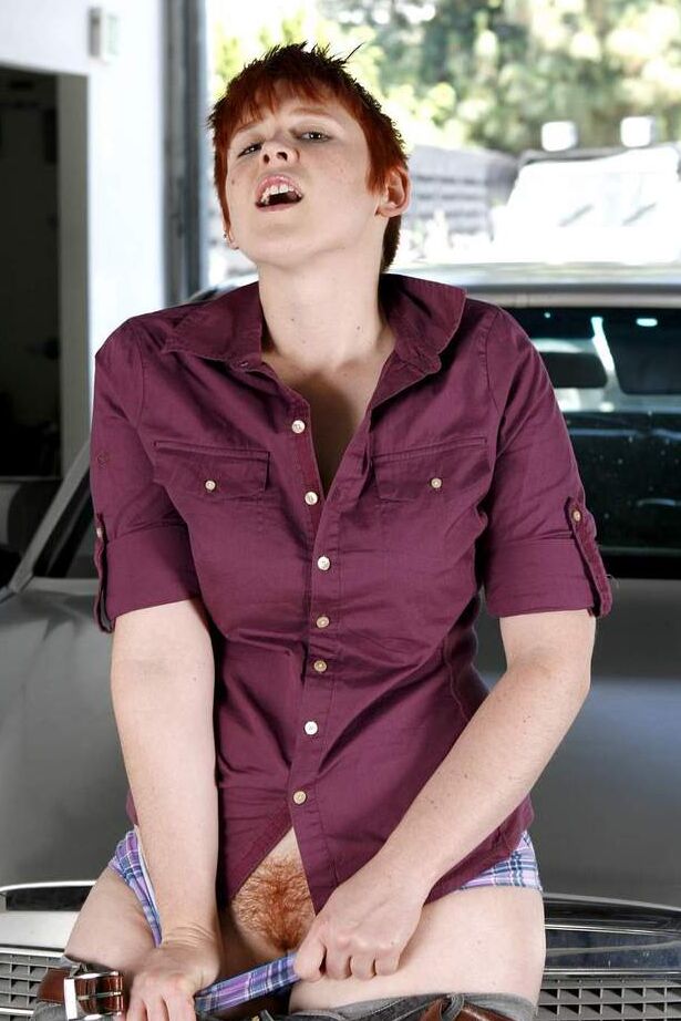 16P Short haired redhead Lily Cade strips naked atop a car in a garage