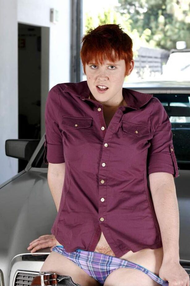 16P Short haired redhead Lily Cade strips naked atop a car in a garage