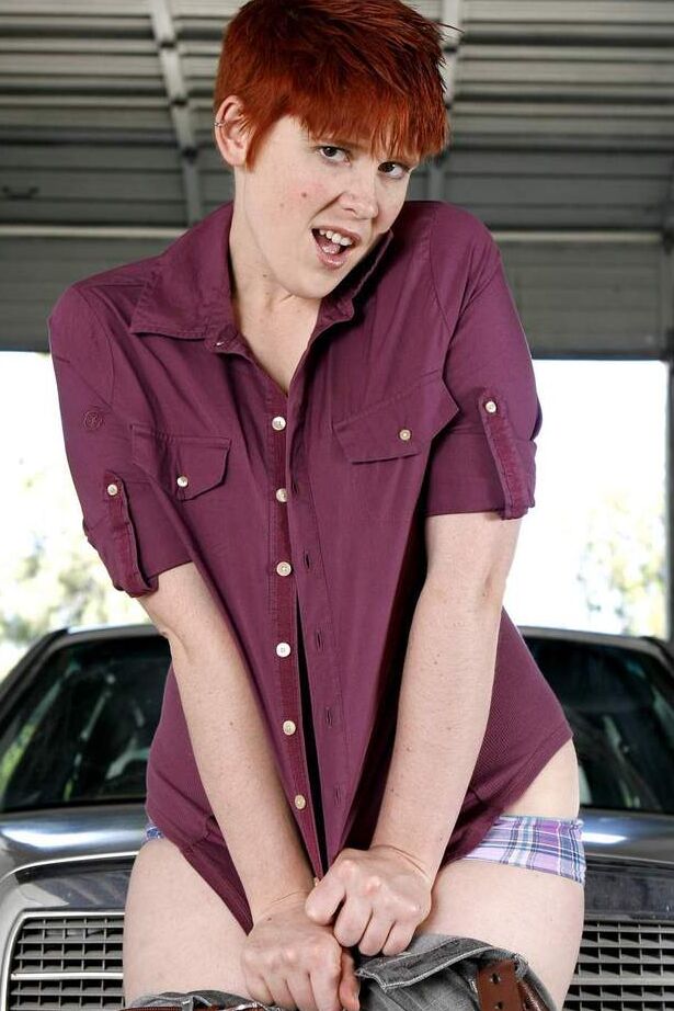 16P Short haired redhead Lily Cade strips naked atop a car in a garage