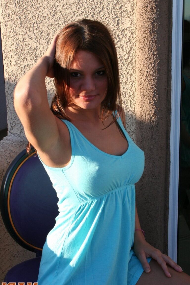 15P Redhead amateur Nadia puts her enhanced tits on display on a balcony