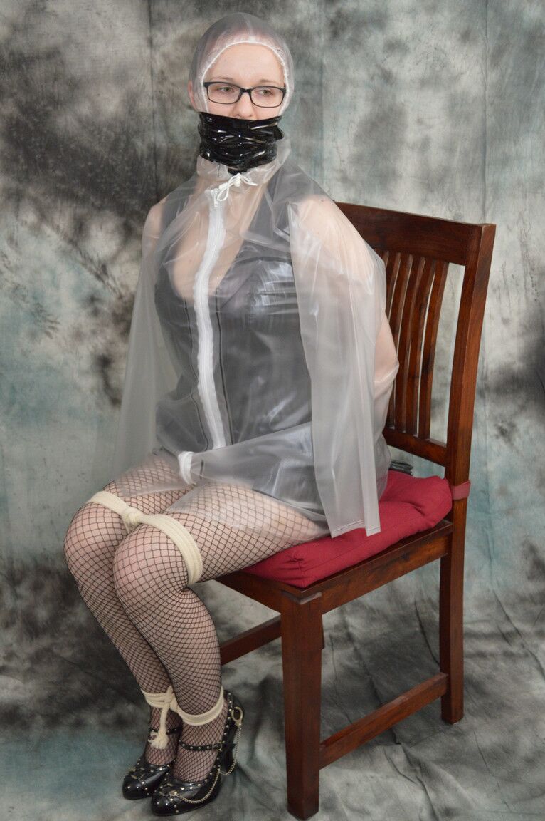16P Redhead Lady Nadja is gagged & restrained before being covered with a raincoat