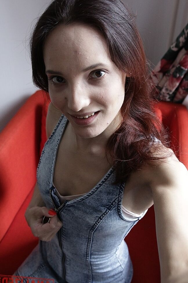 20P Slim amador Mia Sanders mostra seu decote e calcinha em um sofá vermelho