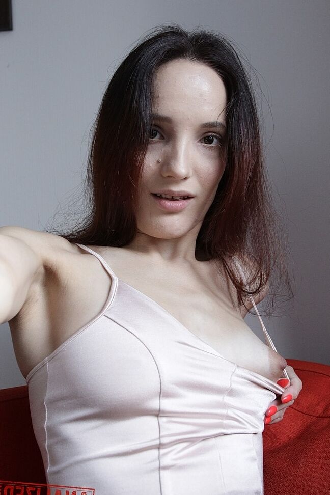 20P Slim amador Mia Sanders mostra seu decote e calcinha em um sofá vermelho