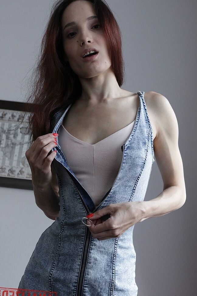 20P Slim amador Mia Sanders mostra seu decote e calcinha em um sofá vermelho