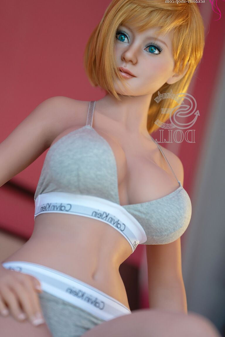 21P Linda boneca sexual pequena mostra seus seios grandes enquanto está deitada no tapete
