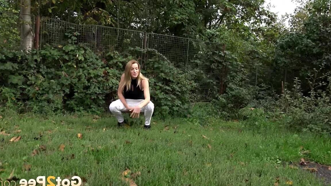 15P Расстроенная женщина стягивает штаны и приседает, чтобы пописать за деревьями.
