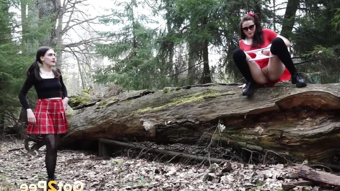 15P Sexy brunette takes a piss on a fallen tree while her girlfriend watches