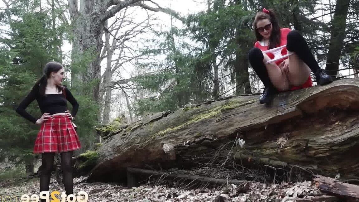 15P Sexy brunette takes a piss on a fallen tree while her girlfriend watches