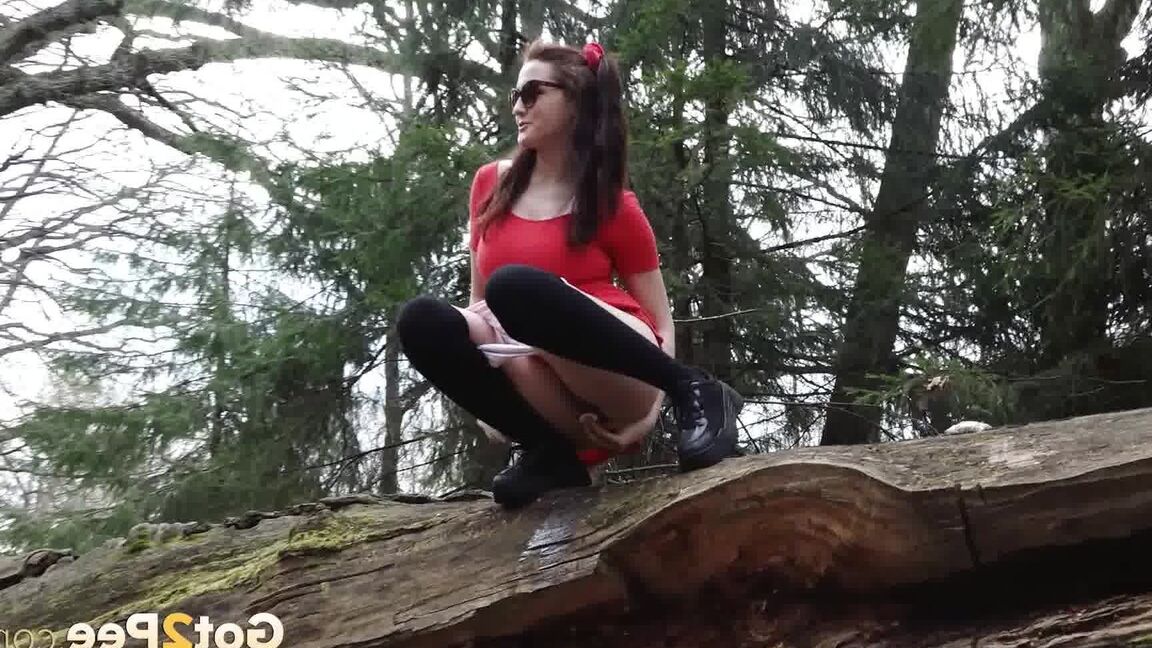 15P Sexy brunette takes a piss on a fallen tree while her girlfriend watches