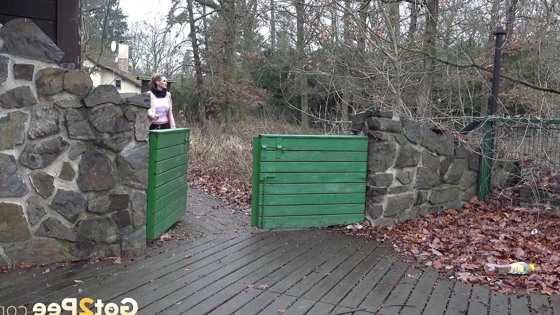 15P White girl Cynthia Vellons takes a piss on a deck behind a stone structure
