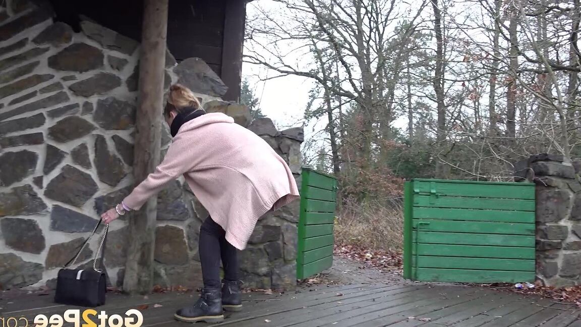 15P White girl Cynthia Vellons takes a piss on a deck behind a stone structure