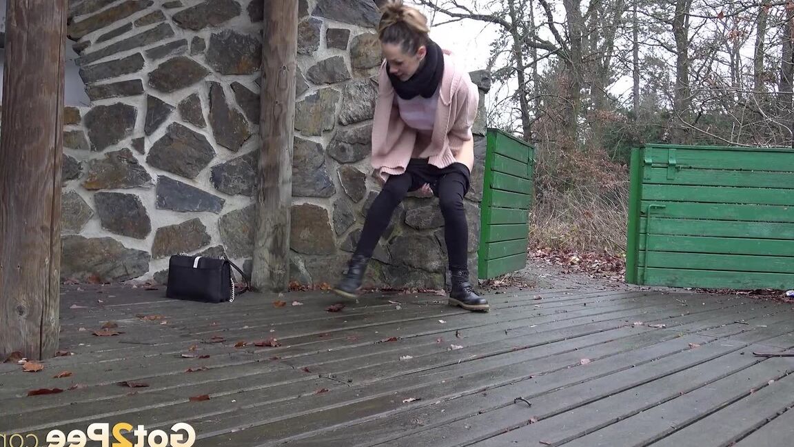 15P White girl Cynthia Vellons takes a piss on a deck behind a stone structure