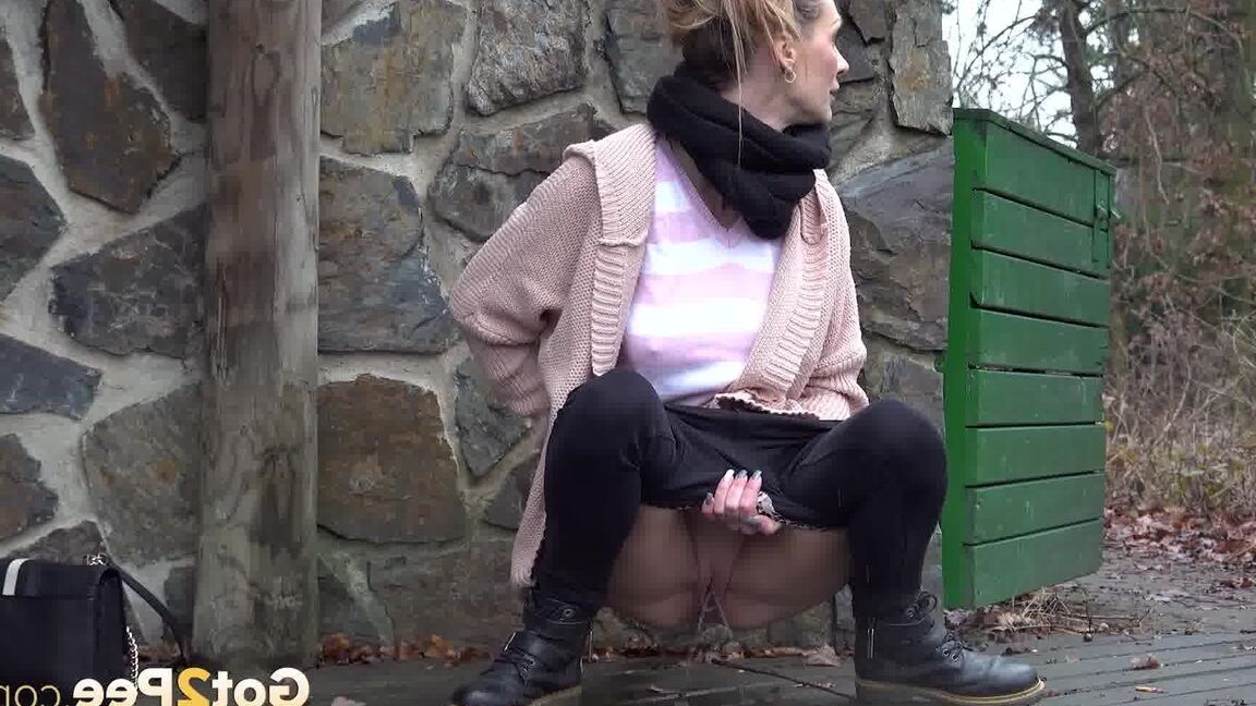 15P White girl Cynthia Vellons takes a piss on a deck behind a stone structure