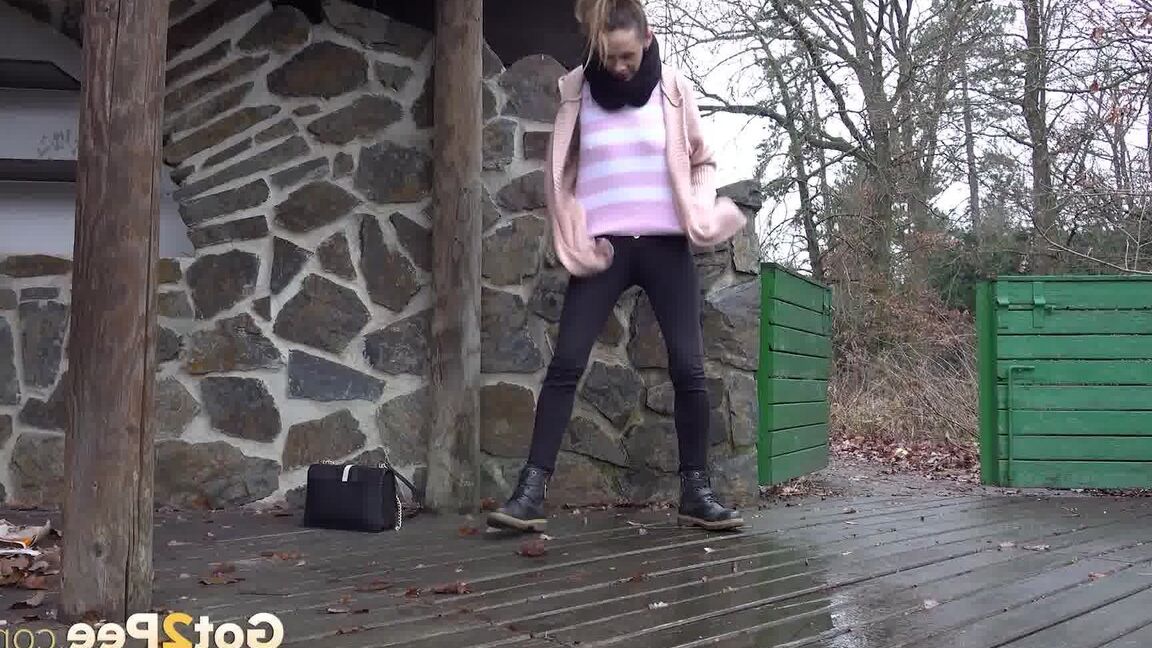 15P White girl Cynthia Vellons takes a piss on a deck behind a stone structure