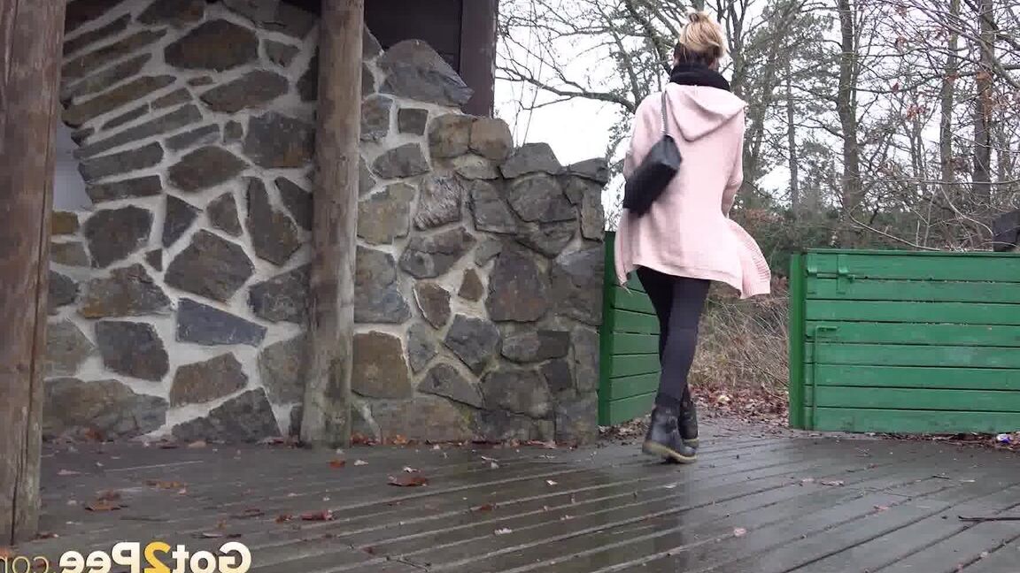 15P White girl Cynthia Vellons takes a piss on a deck behind a stone structure