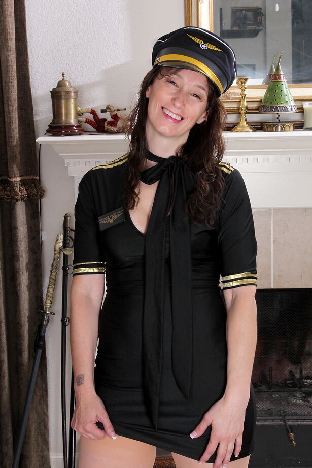 16P 30 plus woman Celeste Carpenter removes her pilot uniform to pose in the nude