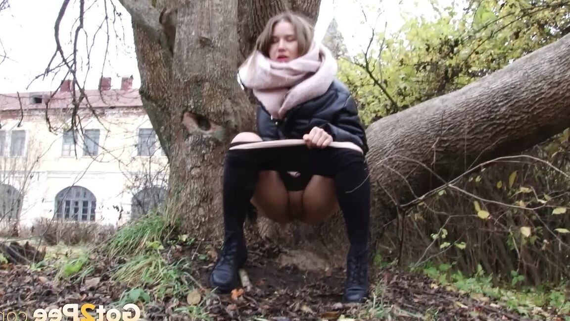 Das 15-jährige kaukasische Mädchen Lera zieht an einem kühlen Tag ihren Schlauch herunter, um an einen Baum zu pinkeln