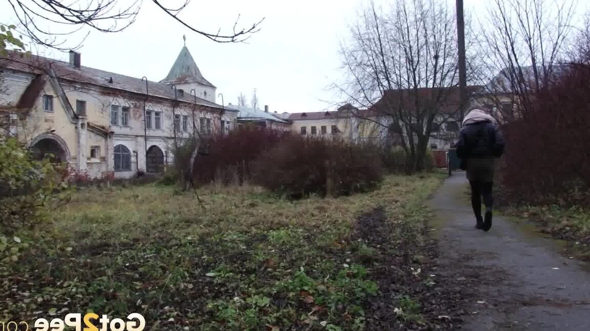 Das 15-jährige kaukasische Mädchen Lera zieht an einem kühlen Tag ihren Schlauch herunter, um an einen Baum zu pinkeln
