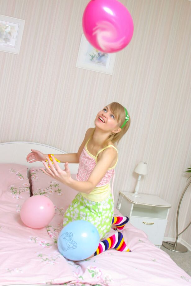 16P La douce jeune Cindy B se met nue sur son lit avec des chaussettes multicolores.